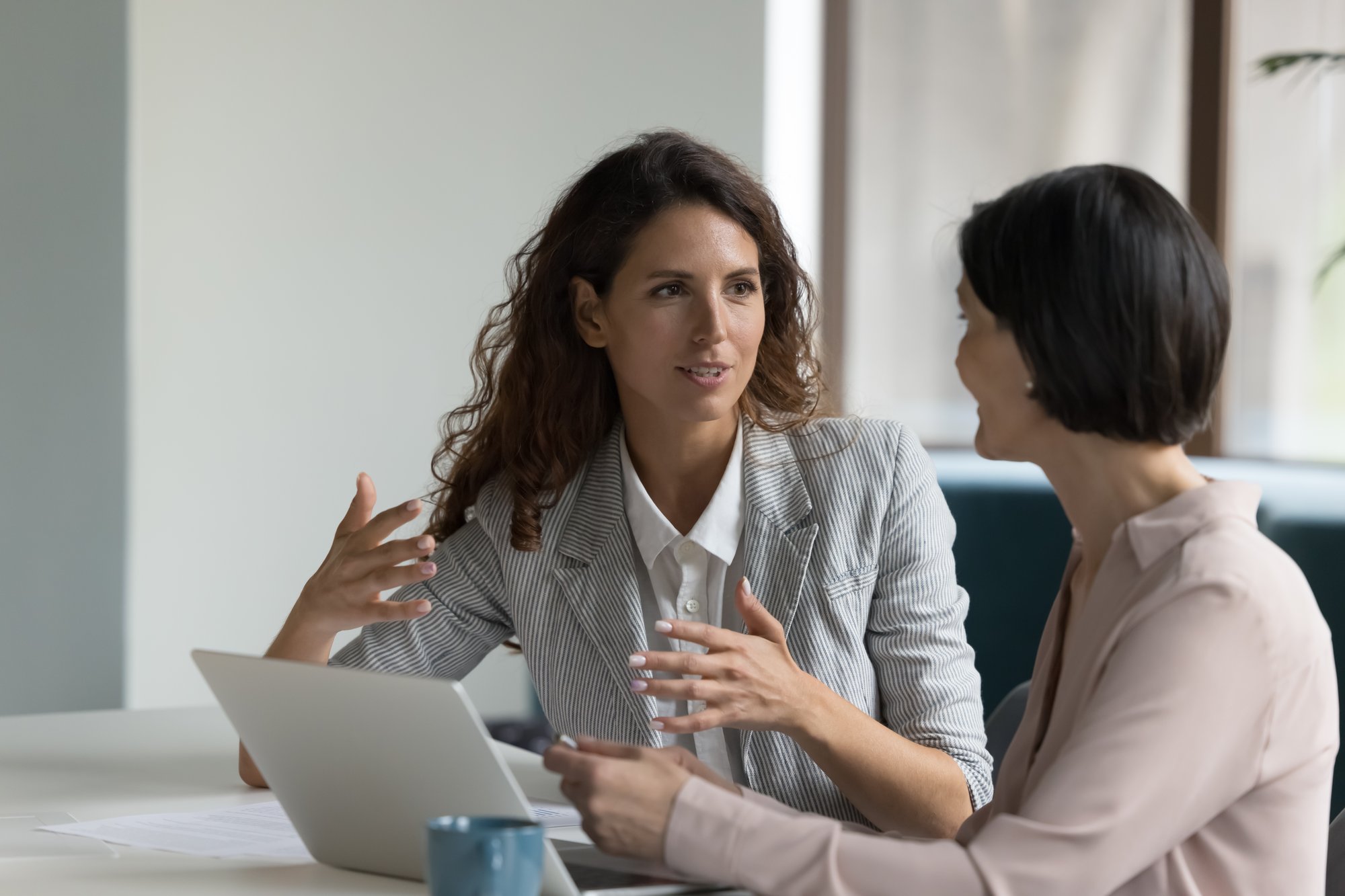 Two women speak animatedly.